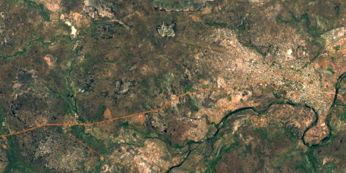 Satellite image of Banafassi in Senegal, showing a river winding across the area, and scrubland with brown and green patches, and a built up area